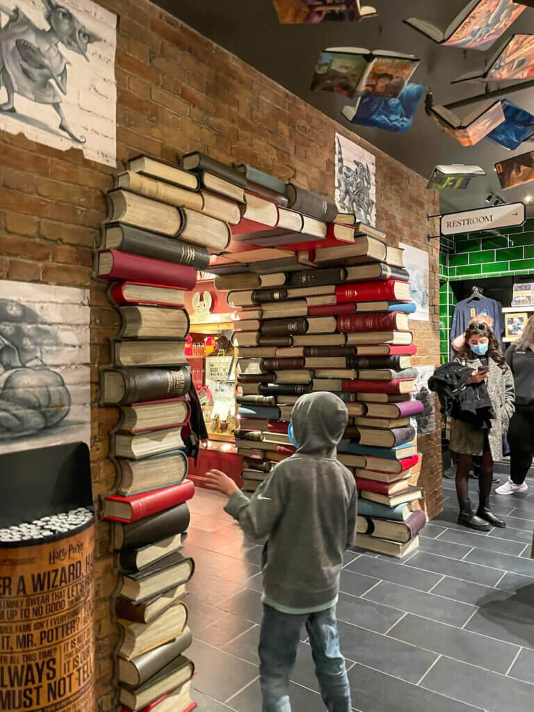 Image of a boy walking through an archway made of books