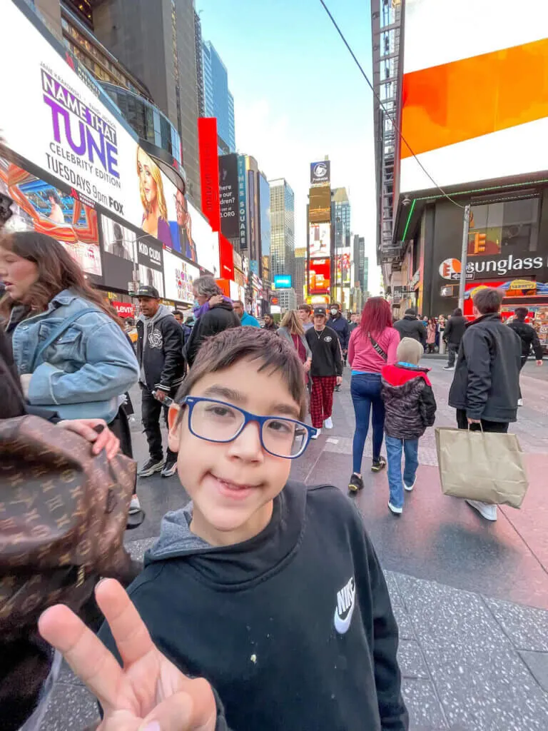 Image of a boy doing a peace sign in Times Square in NYC