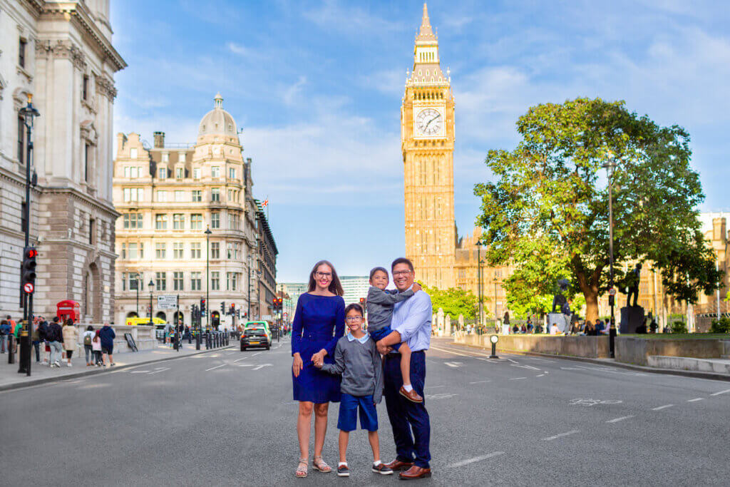 Find out how to book London family photos from top family travel blog Marcie in Mommyland. Image of a family posing in the street in front of Big Ben.