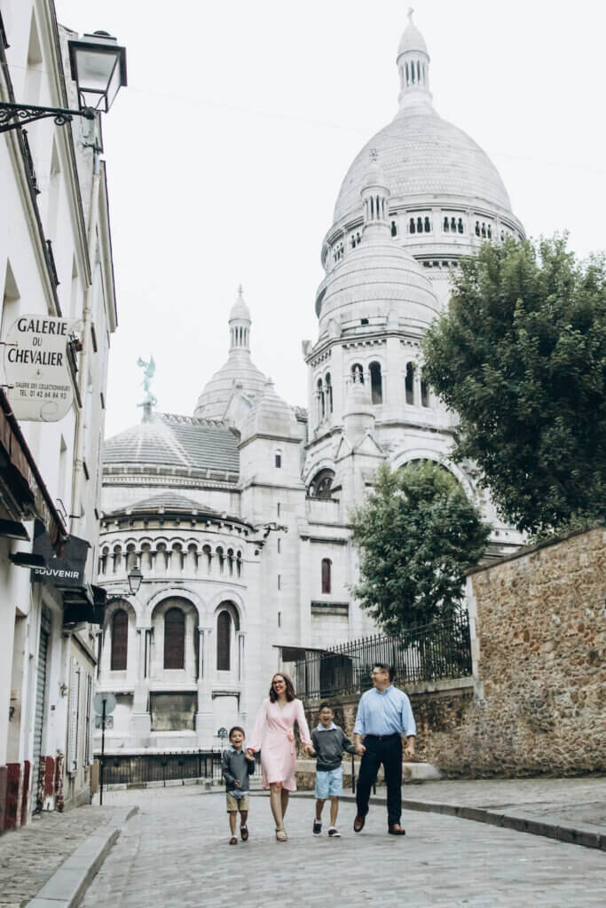 Image of a family walking down the street in Paris with Sacre Couer in the background