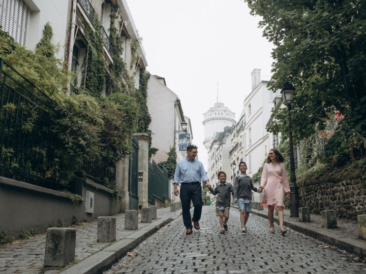 Find out how to get the perfect Paris family photos by top family travel blog Marcie in Mommyland. Image of a family walking down the street in Montmartre Paris