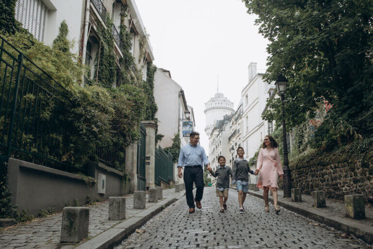 Find out how to get the perfect Paris family photos by top family travel blog Marcie in Mommyland. Image of a family walking down the street in Montmartre Paris