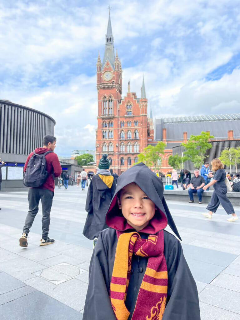 Image of a boy wearing a Harry Potter robe and scarf positing in front of a clock tower in London