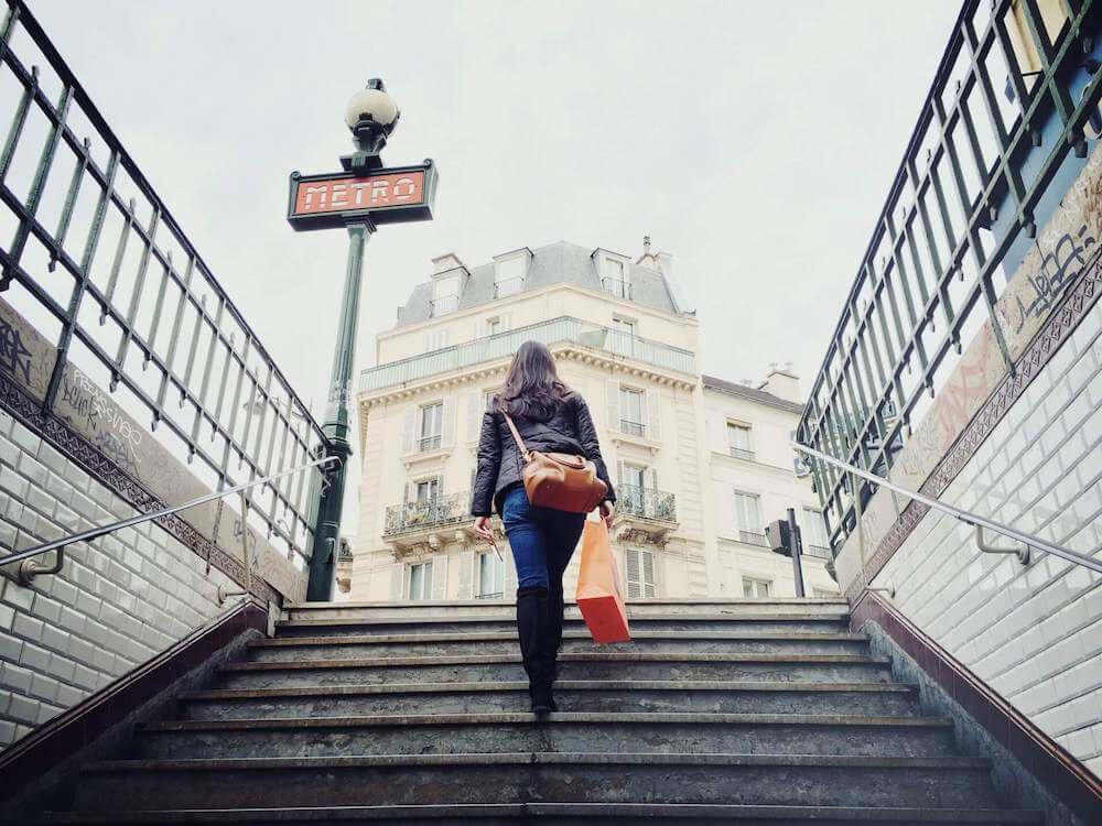 Image of a woman climbing the stairs of a Paris metro station