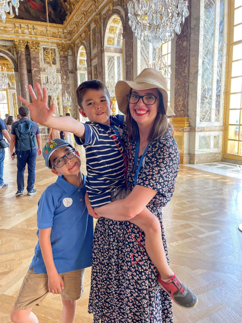 Image of a mom and two boys inside the Palace of Versailles in Paris France