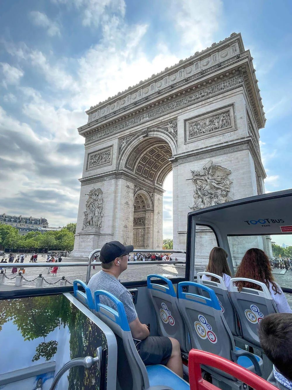 Image of a man on a double decker bus in front of the Arc de Triomphe