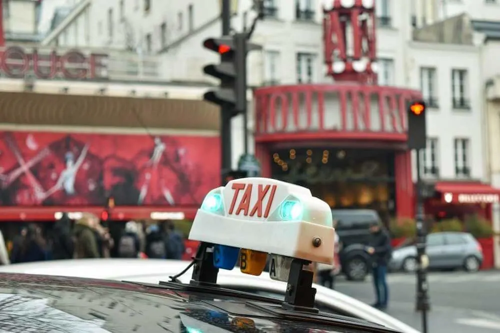 Image of a taxi in front of the Moulin Rouge in Paris