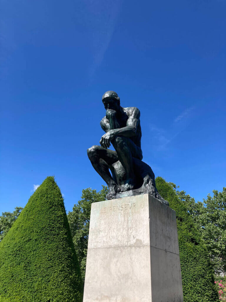 Image of Rodin's The Thinker statue outdoor surrounded by trees