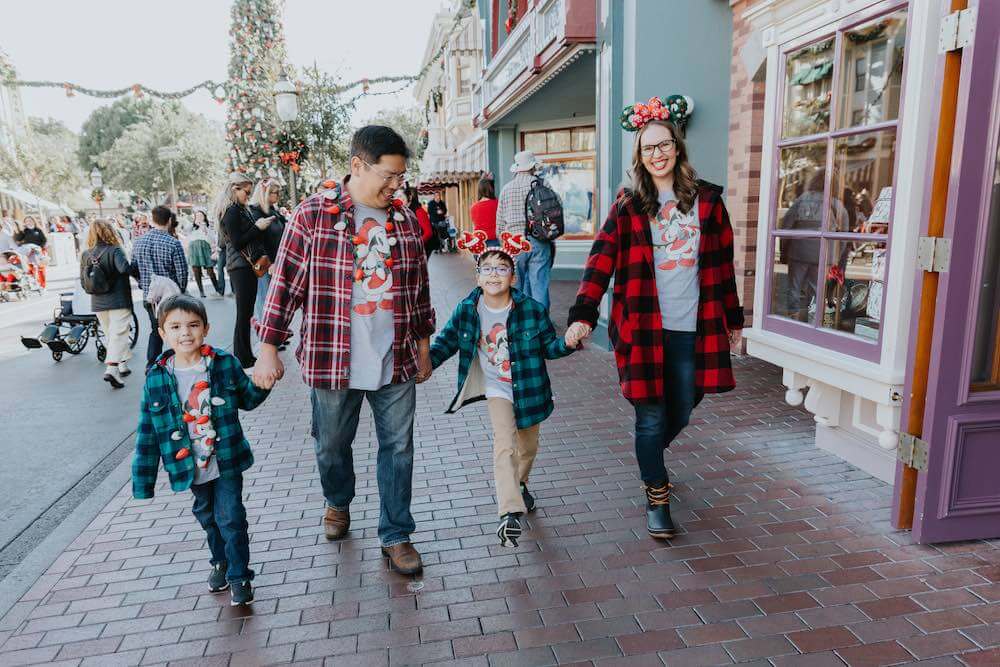 Image of a family holding hands while walking down Main Street at Disneyland