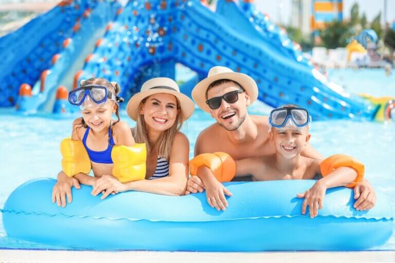 Check out the best Cabo San Lucas all-inclusive family resorts recommended by top family travel blog Marcie in Mommyland. Image of Happy family resting in aqua park