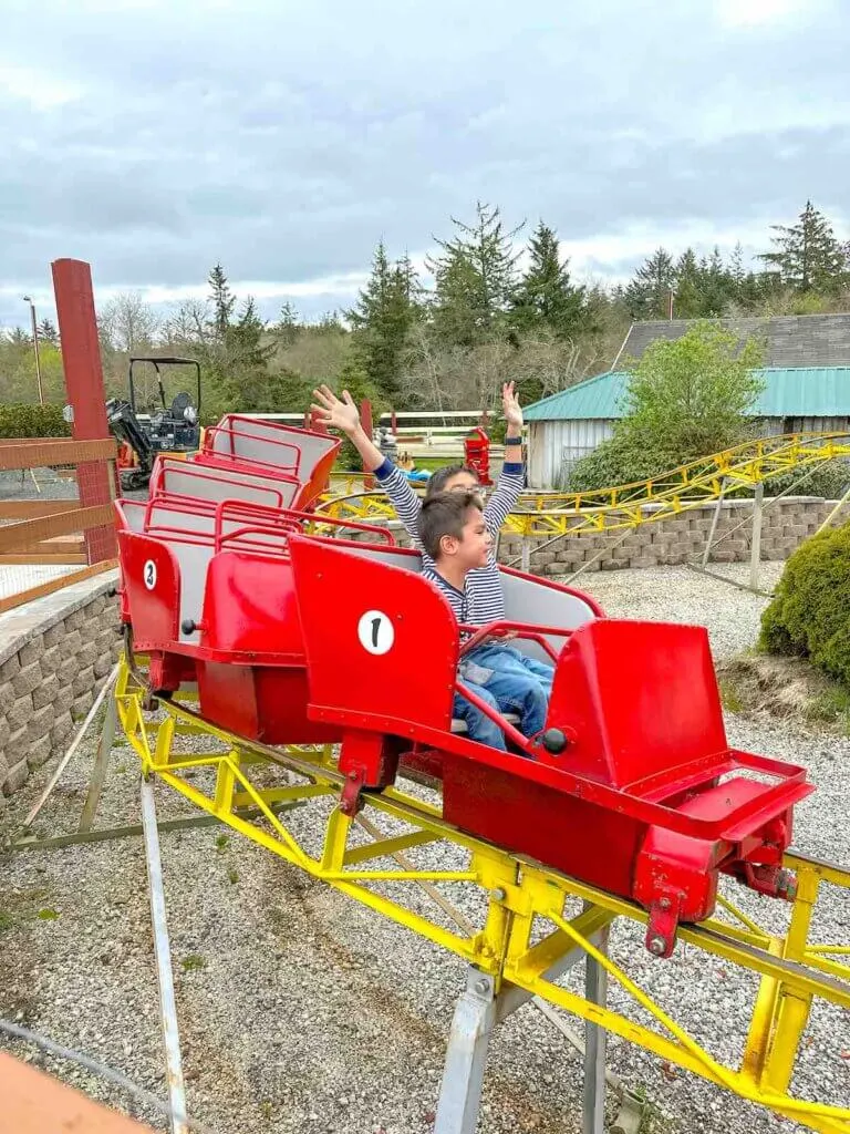 Image of two boys riding in a red roller coaster at Captain Kid Amusement Park in Seaside Oregon