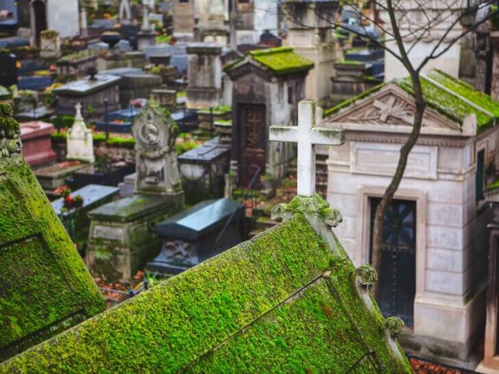 Check out these amazing hidden gems in Paris recommended by top family travel blog Marcie in Mommyland. Image of an old Paris cemetery