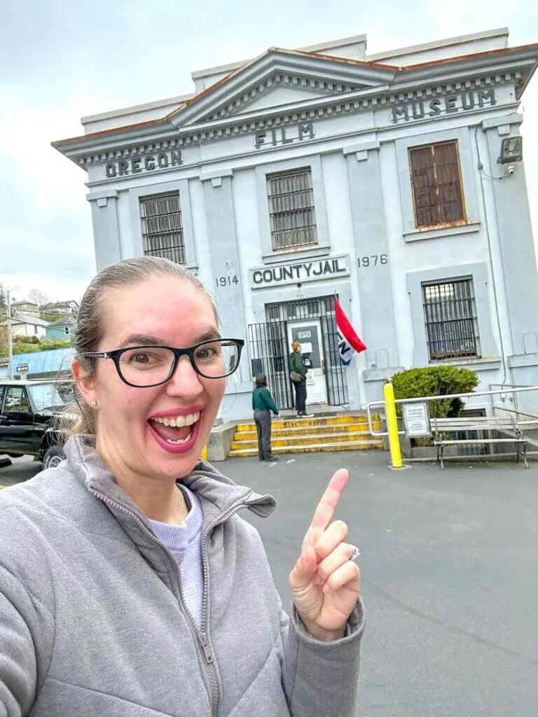 Image of a woman pointing at the Oregon Film Museum in Astoria Oregon