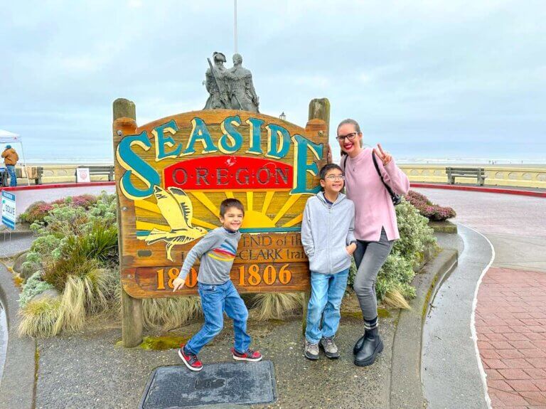 Check out the best things to do in Seaside Oregon recommended by top family travel blog Marcie in Mommyland. Image of a mom and two boys by the Seaside Oregon sign