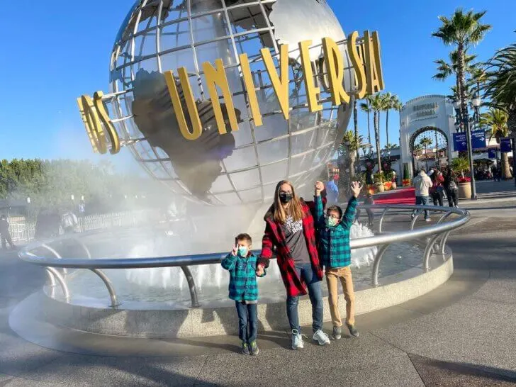 Check out the best things to do at Universal Studios Hollywood at Christmas by top family travel blog Marcie in Mommyland! Image of a mom and two boys wearing plaid in front of the Universal Studios Hollywood Globe