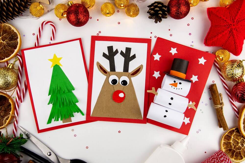 DIY Christmas cards kids. Three cards with a Christmas tree, a deer, a snowman from colored paper.