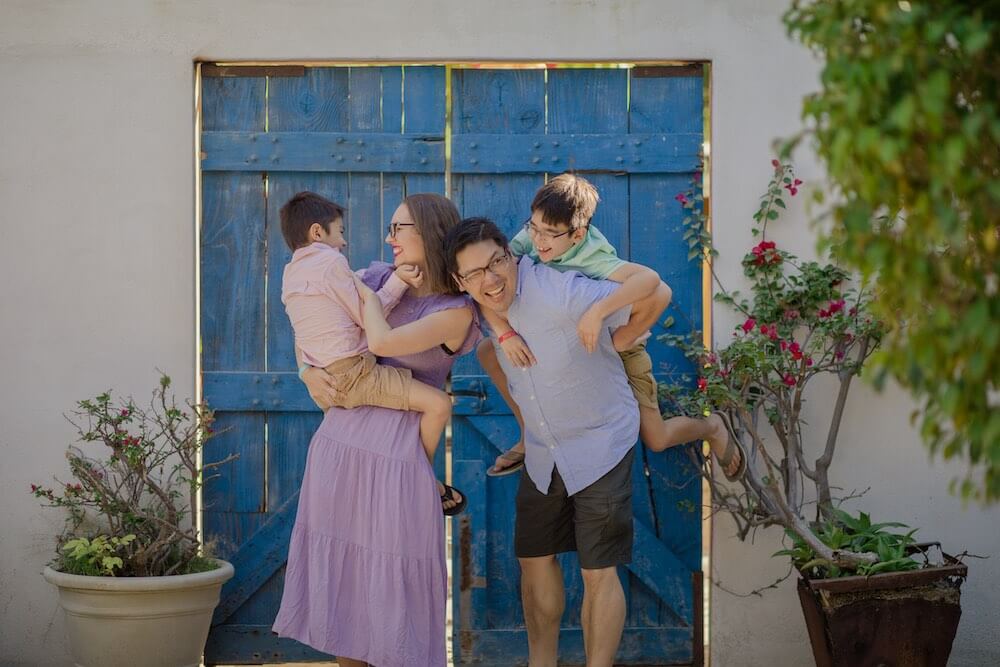 Image of parents holding their kids in front of a blue door in Cabo San Lucas Mexico