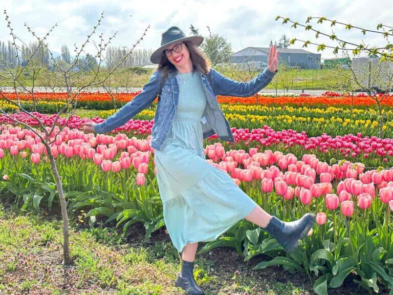 Check out this updated guide to the Skagit Valley Tulip Festival by top Seattle blog Marcie in Mommyland. Image of a woman posing in a tulip field