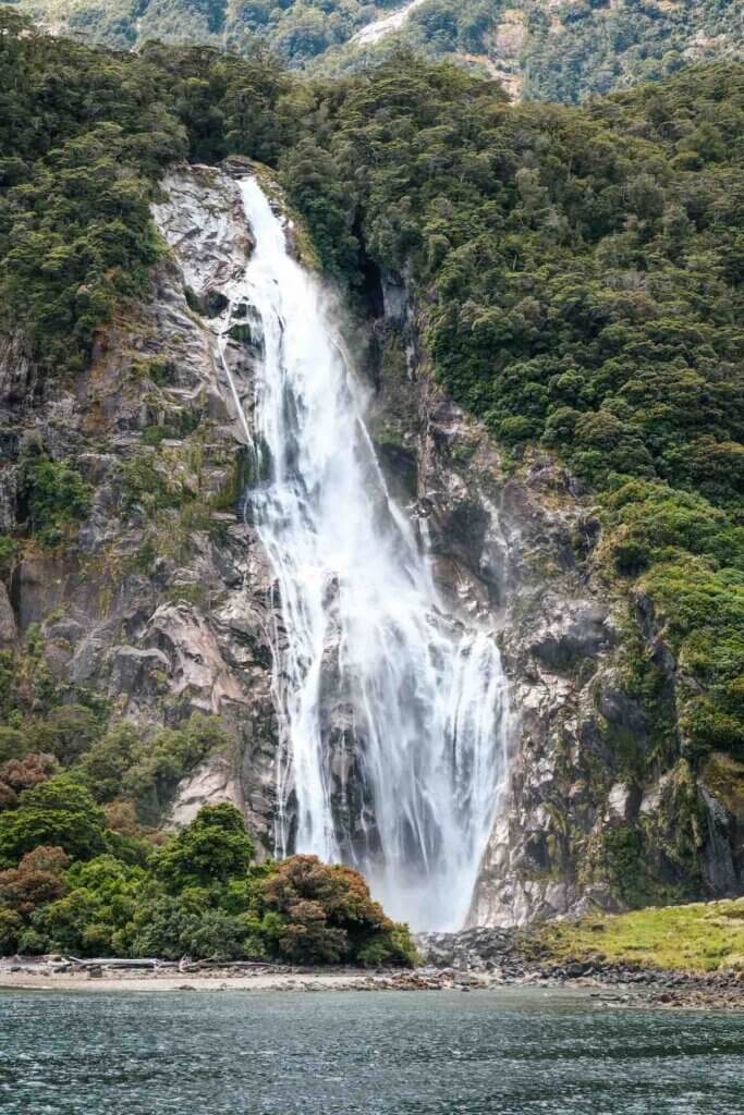 Bowen Falls cascading over rocks into Milford Sound in Fiordland on the South Island of New Zealand