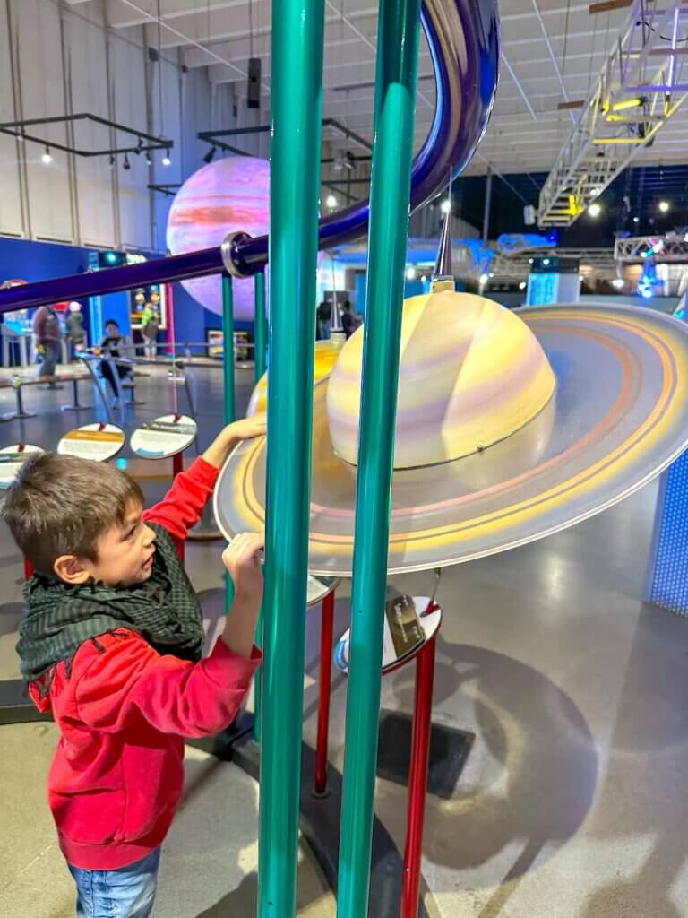 Image of a boy playing with Saturn at the Pacific Science Center in Seattle.