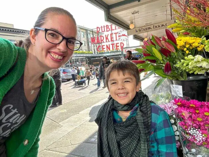 Check out this 3 Days in Seattle Itinerary by top Seattle family travel blog Marcie in Mommyland. Image of a mom and boy taking a selfie at Pike Place Market