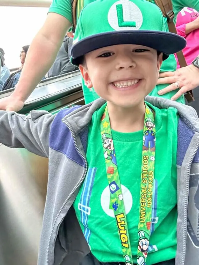 Image of a boy wearing a Luigi hat, shirt, and lanyard