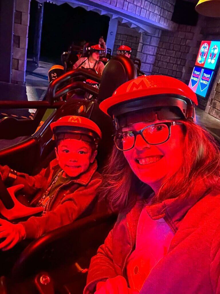 Image of a mom and son in the Mario Kart Bowser's Challenge ride at Super Nintendo World at Universal Studios Hollywood.