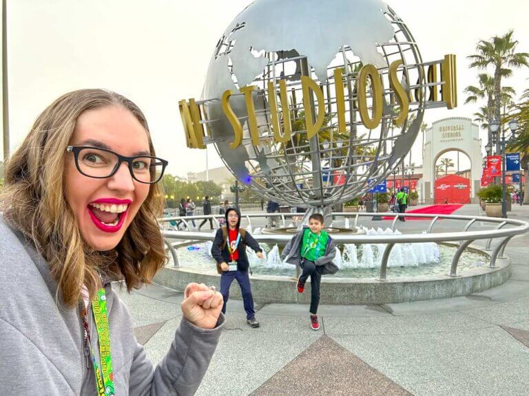 Don't miss these must-read tips for Universal Studios Hollywood with kids by top family travel blog Marcie in Mommyland. Image of a mom and two boys taking a selfie in front of the Universal Studios Hollywood sign