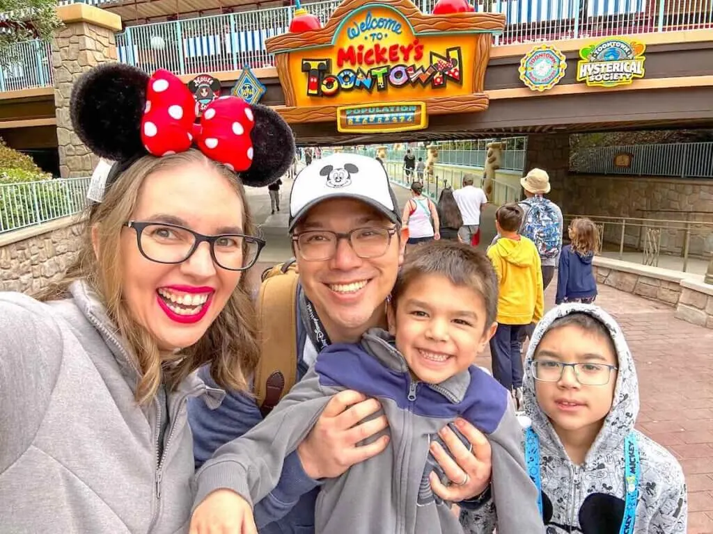 Image of a family taking a selfie in front of the Mickey's Toontown sign