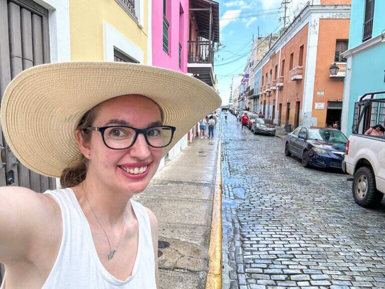 Check out this detailed comparison of Hawaii vs Puerto Rico by top family travel blog Marcie in Mommyland. Image of a woman taking a selfie in Old San Juan Puerto Rico