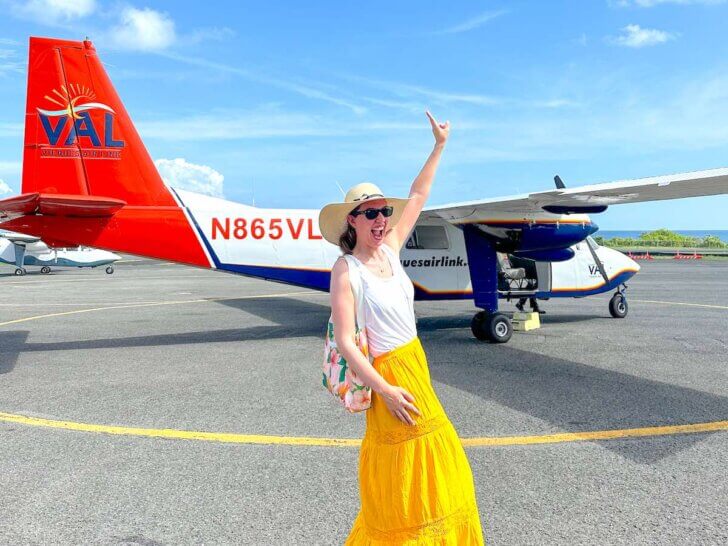 Check out this ultimate guide to Puerto Rico island hopping by top family travel blog Marcie in Mommyland. Image of a woman posing by a small plane