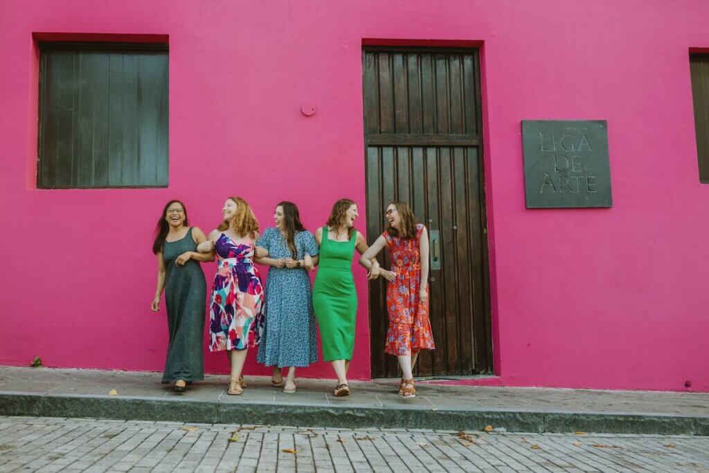 Image of 5 women in front of a magenta pink building in Puerto Rico