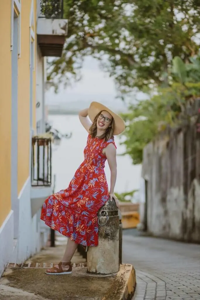 Image of a woman in a red dress posing on a bench in Old San Juan Puerto Rico