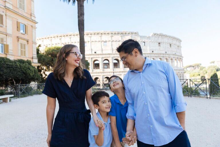 Check out these tips for finding affordable Rome photographers by top family travel blog Marcie in Mommyland. Image of a family in front of the Colosseum in Rome Italy