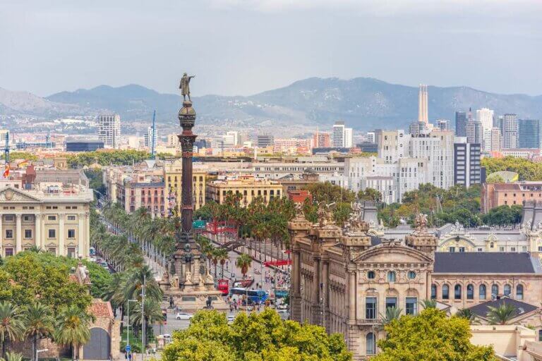 Find out the best Barcelona hotels for families visiting Spain with Kids recommended by top family travel blog Marcie in Mommyland. Image of Aerial view over square Portal de la pau, and Port Vell marina and Columbus Monument in Barcelona, Catalonia, Spain