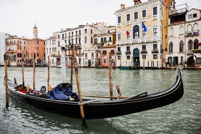 Check out the best Venice hotels for families visiting Italy with kids recommended by top family travel blog Marcie in Mommyland. Image of a gondola in Venice