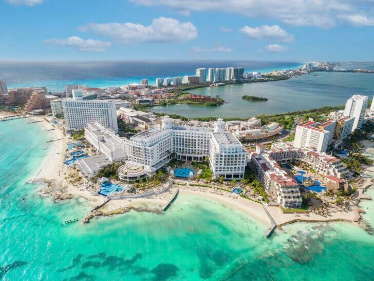 Check out these essential Cancun travel tips for first-timers recommended by top family travel blog Marcie in Mommyland. View of beautiful Hotels in the hotel zone of Cancun. Riviera Maya region in Quintana roo on Yucatan Peninsula. Aerial panoramic view ofallinclusive resorts