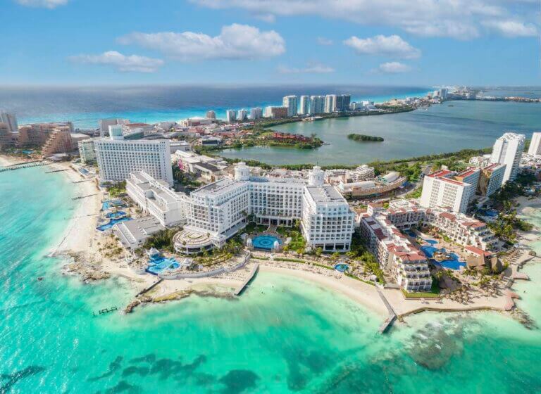 Check out these essential Cancun travel tips for first-timers recommended by top family travel blog Marcie in Mommyland. View of beautiful Hotels in the hotel zone of Cancun. Riviera Maya region in Quintana roo on Yucatan Peninsula. Aerial panoramic view ofallinclusive resorts