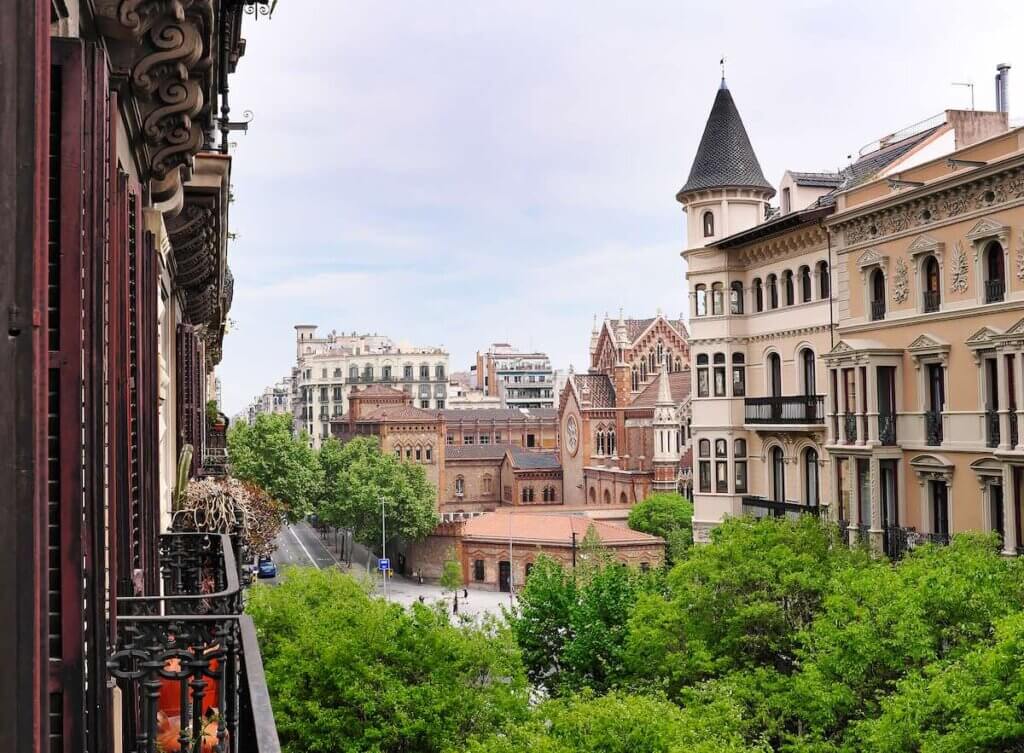 View into  Valencia street in Barcelona - residential Eixample district with church in background, Spain