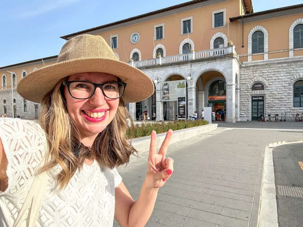 Image of a woman in front of the Pisa Centrale train station in Italy