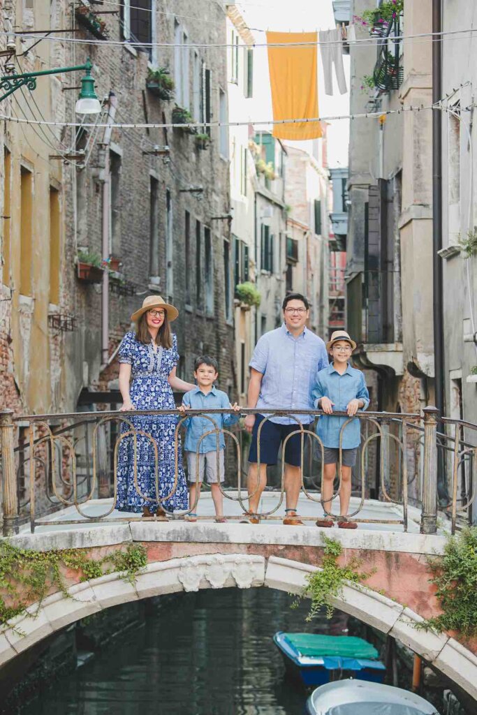Image of a family posing on a little bridge in Venice, Italy