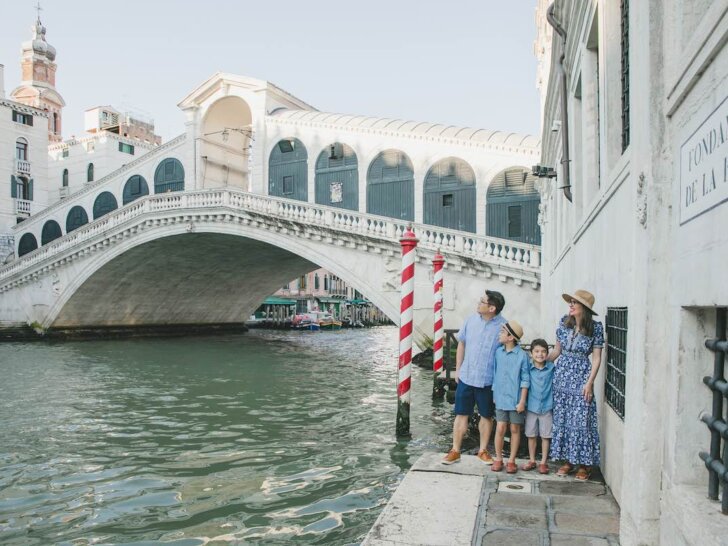 Find out where to book affordable Venice photographers with tips by top family travel blog Marcie in Mommyland. Image of a family by the Rialto Bridge in Venice