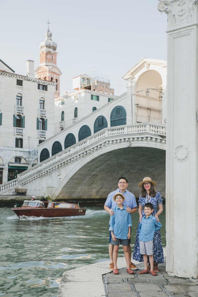 Image of a family posing in front of the Rialto Bridge for a Venice photography session