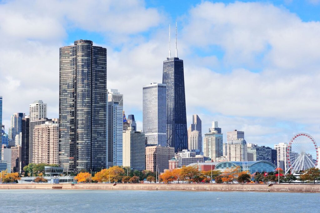Image of Chicago city urban skyline with skyscrapers over Lake Michigan with cloudy blue sky.