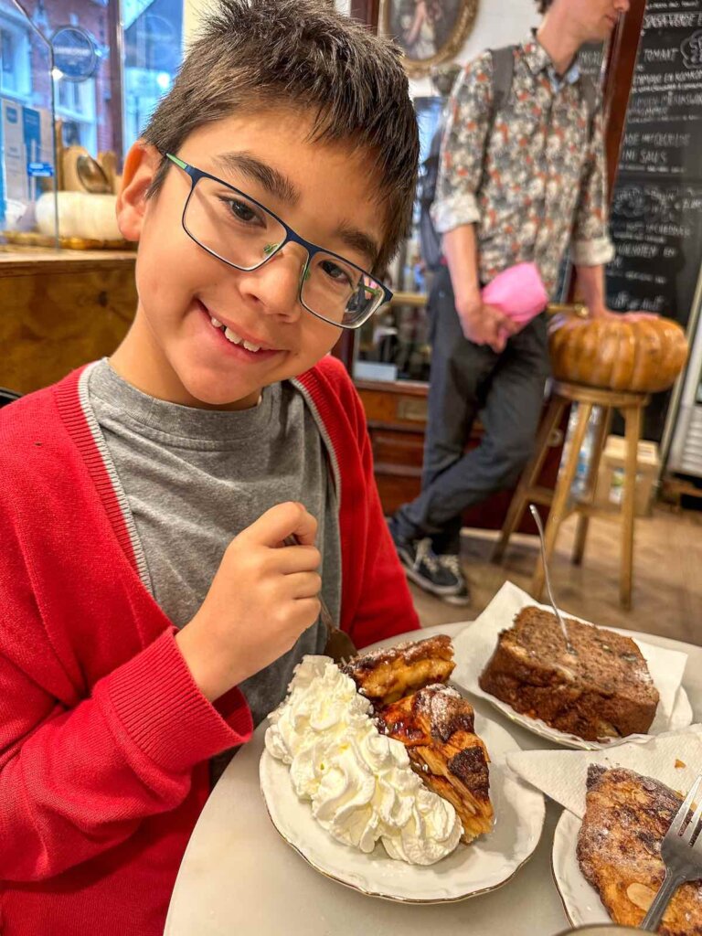 Image of a boy with apple pie and whipped cream at an Amsterdam cafe