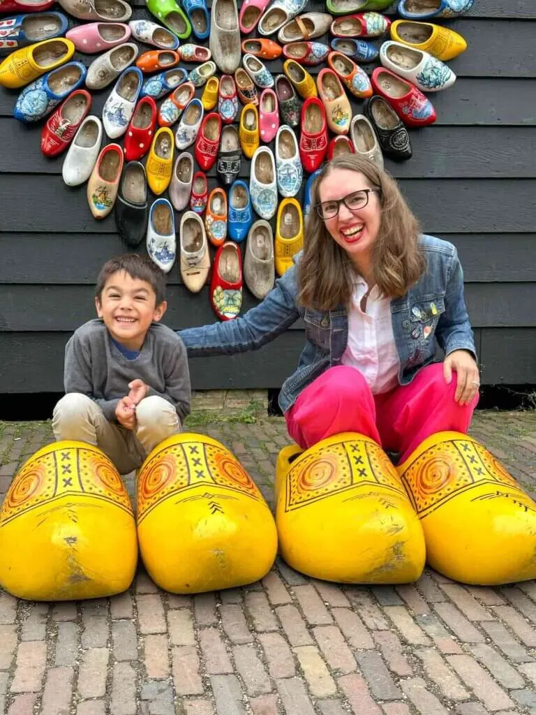 Image of a mom and son wearing oversized Dutch wooden shoes at Zaanse Schans in Amsterdam