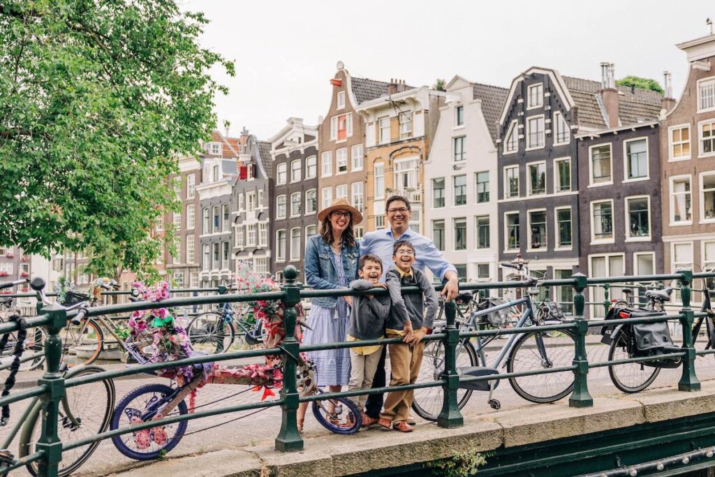 Image of a family posing on a bridge in Amsterdam with bikes
