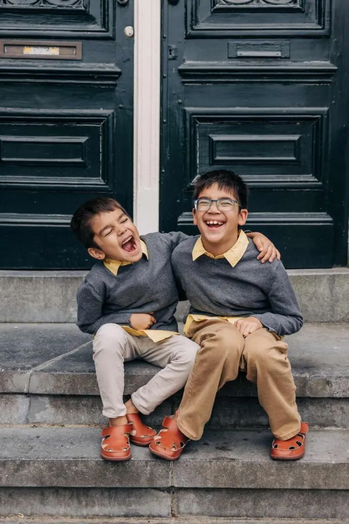 Image of two boys laughing together on a stoop in Amsterdam