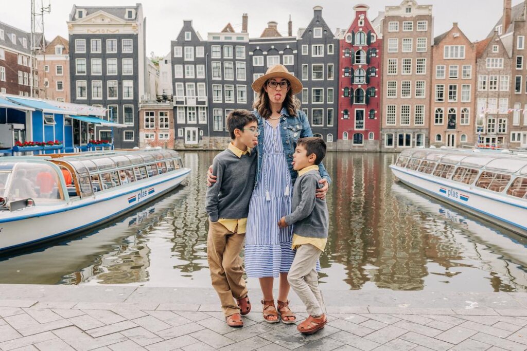 Image of a mom and two boys sticking their tongues out near a canal in Amsterdam