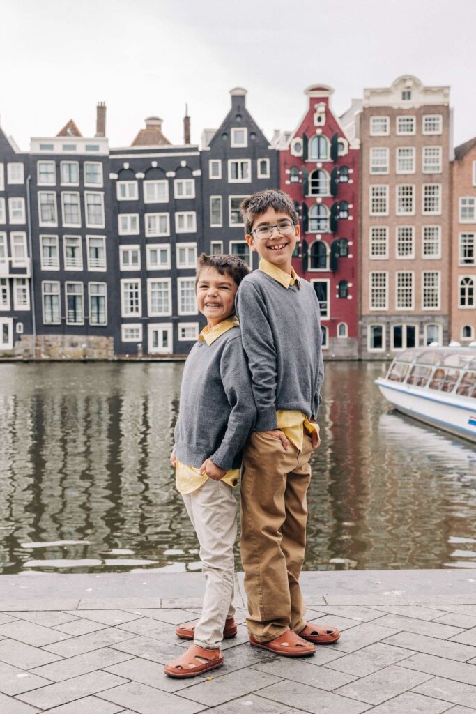 Image of two boys back to back in front of a canal in Amsterdam